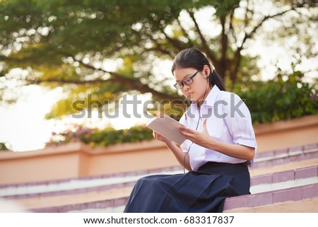 Thai student girl reading a books at the park