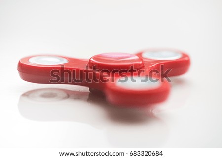 Red hand Spinner. Stress relieving toy on white background. Close-up. Top view. Stock photo