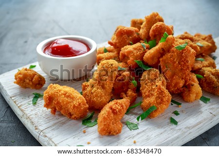 Fried crispy chicken nuggets with ketchup on white board Royalty-Free Stock Photo #683348470