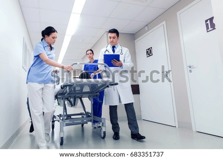 profession, people, health care, reanimation and medicine concept - group of medics or doctors carrying unconscious woman patient on hospital gurney to emergency Royalty-Free Stock Photo #683351737