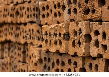 Close up of beside red clay block for wall construction. Texture of clay brick wall design with holes.