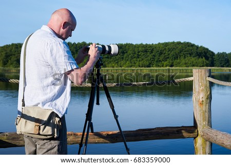  Photographer on a lake in the Mueritz National Park in Germany                              