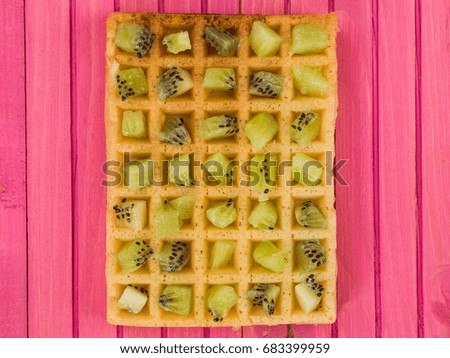 Kiwi Fruit on a Toasted Waffle Against a Pink Wooden Background