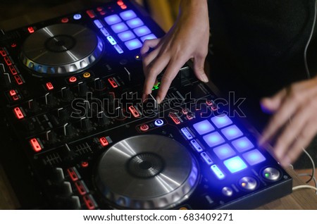 Hands disc jockey at the turntable. DJ plays on the best, famous CD players at nightclub during party. EDM, party concept 