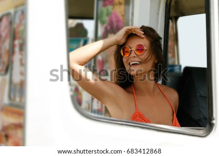Happy woman sitting inside an old van