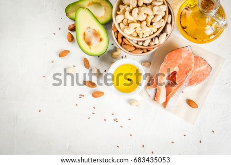 Healthy food. Products with healthy fats. Omega 3, omega 6. Ingredients and products: trout (salmon), flaxseed oil, avocado, almonds, cashews, pistachios. On a white stone table. Copy space top view Royalty-Free Stock Photo #683435053