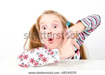 studio shot of pretty little girl pointing at her watch