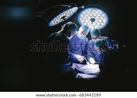 Group of surgeons in hospital operating theater. Medical team performing surgery in operation room. Royalty-Free Stock Photo #683443189