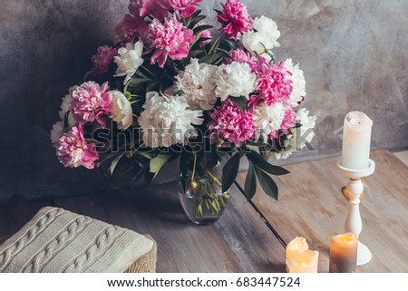 Beautiful romantic interior in loft style with candles and a bouquet of peonies