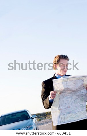 young businessman lost in the desert using a map