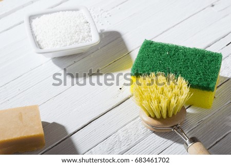 citric acid, cleaning brush, sponge and bar of soap on white wooden table background
