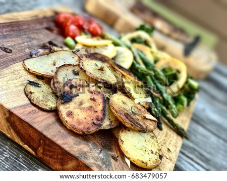 Wooden serving board with freshly grilled vegetables at a cookout