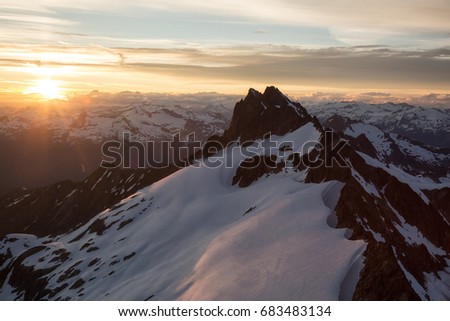 Aerial landscape view of a beautiful mountain peak during a bright summer sunset. Picture taken of Tantalus Range in Squamish, North of Vancouver, British Columbia, Canada.