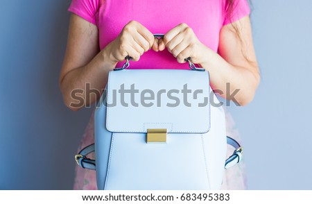 Close up stylish woman in pink skirt with blue bag. Fashion concept.