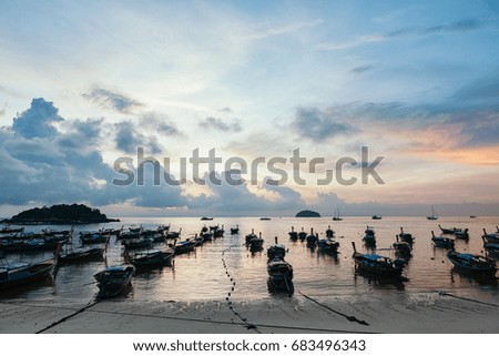 Beautiful sea and beach with over group of long tail boats at sunrise or sunset, skyline, clouds, Koh Lipe island, Satun,Thailand.