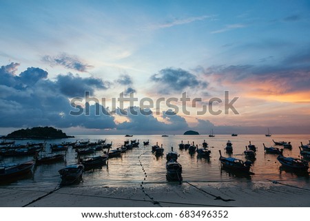 Beautiful sea and beach with over group of long tail boats at sunrise or sunset, skyline, clouds, Koh Lipe island, Satun,Thailand.