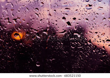Background, wet fogged glass film with drops of water and dew during the rain at sunset