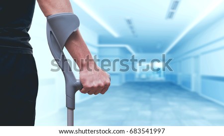 Injured man trying to walk on crutches. Blurred background Royalty-Free Stock Photo #683541997