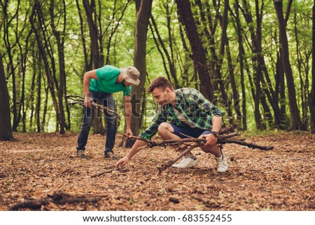 Close up photo of two guys friends in the wood in fall, collecting wood for a camp fire, nice view of a forest in the autumn Royalty-Free Stock Photo #683552455