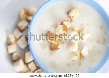 Two blue bowls of onion pureed soup with croutons