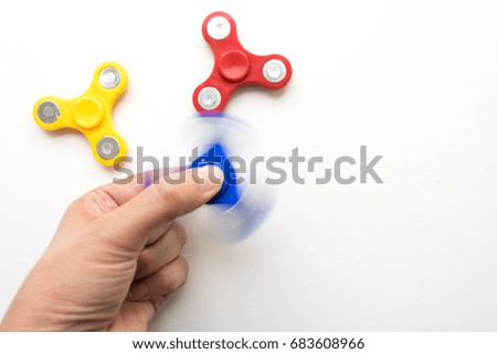 Hand playing with a spiner. Stress relieving toy on white background. Close-up. Top view. Nobody. Stock photo