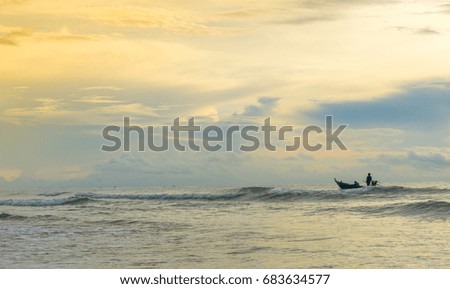 A man is sailing through waves in the sea. Like work to overcome the obstacles.Silhouette picture