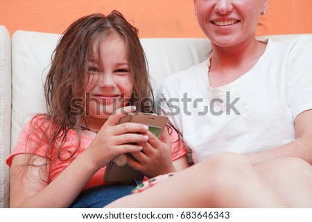 happy family. mother and daughter relaxing at home sitting on the couch