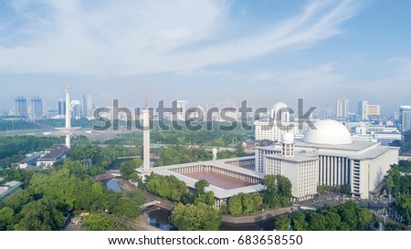 Aerial view of Istiqlal Mosque with skyscrapers under blue sky at Jakarta, Indonesia
