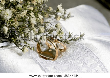 a couple of golden wedding ring with white flower bouquet