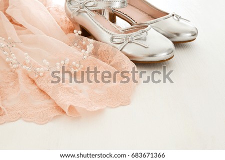 Vintage tulle pink chiffon dress and silver shoes on wooden white floor. Wedding, bridesmaid and girl's party concept