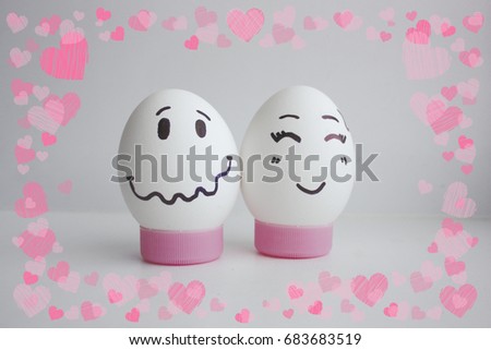 Cheerful eggs with two face on white background on stand concept of embarrassed shyness.Photo for your design Frame of hearts. love