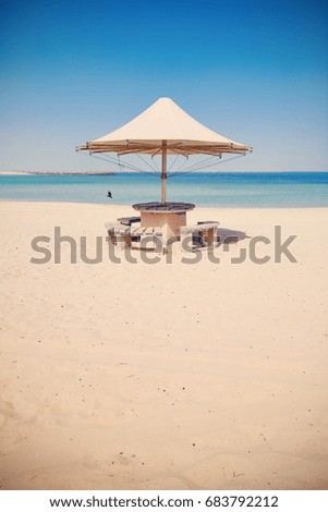 Retro toned picture of an umbrella on an empty tropical beach.