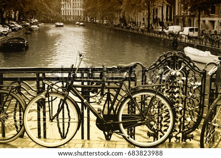 Vintage scene of bike in Amsterdam city next to amstel river canal..