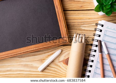 Back to school background with school supplies over wooden board. Top view.
