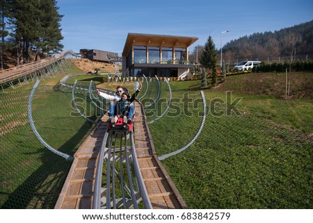 Excited young couple enjoys driving on alpine coaster