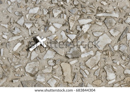 Christian cross on the background of a coating of stone crumbs. Religion, faith.