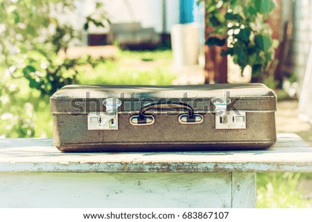 Vintage brown leather suitcase on a wooden table. The concept of travel. Natural light, selective focus