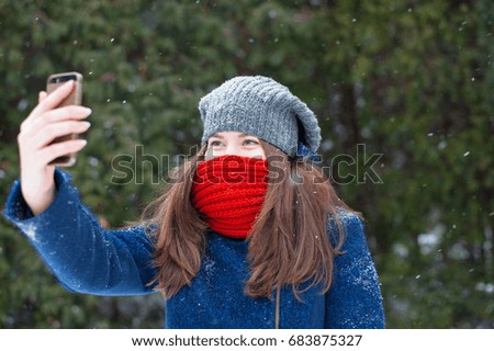 Young beautiful woman taking selfie photo in winter snow park