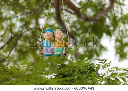 Ceramic doll hung swing in the garden