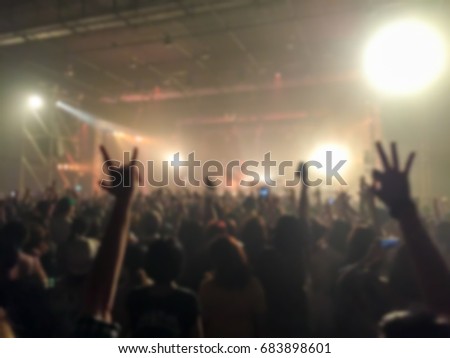 Abstract blurred of concert with hands up having fun