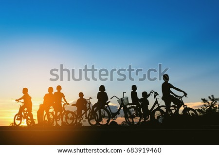 Children ride a bike ,sunset background