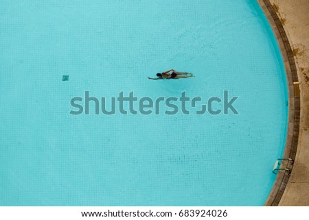Asian woman swimming in the pool view from above minimal concept