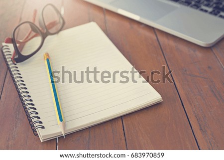 Wooden table with notepad, computer and coffee cup. View from above with copy space.
