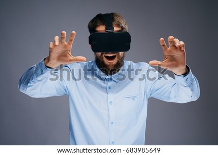 Man plays in 3d glasses on a gray background                               