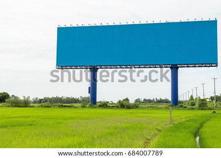 Empty large white advertising billboard in green rice field. for design and advertisement concept