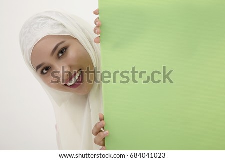 malay woman with tudung,behind of the green placard