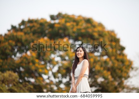 Pretty Thai girl at the park with tree blurred background