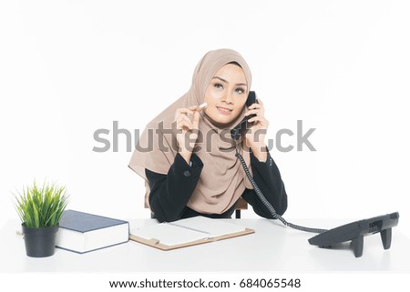 The concept of a young Muslim woman in the office uses the phone