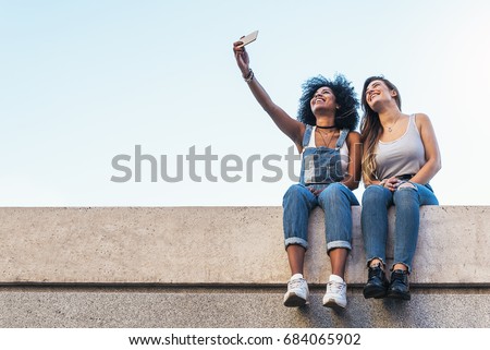 Beautiful women taking a self portrait in the Street. Youth concept.