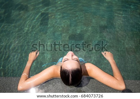 Top view of relaxed woman sitting in swimming pool